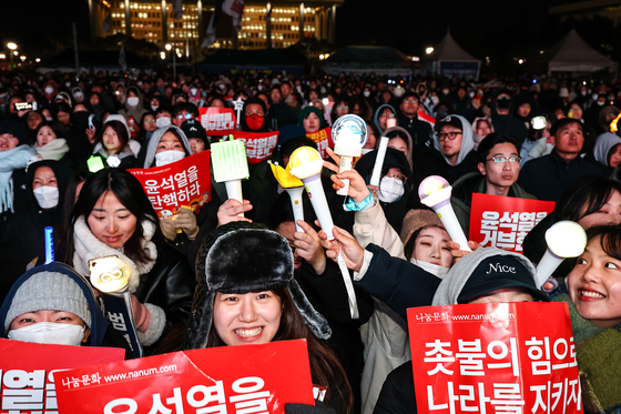 Protesters wave K-pop light sticks during a rally calling for President Yoon Suk Yeol's impeachment in Yeouido, Seoul, on Saturday. [JOONGANG ILBO]