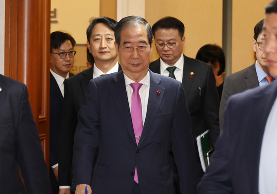 Prime Minister Han Duck-soo and Cabinet members exit the Government Complex Seoul in Jongno District after concluding a Cabinet meeting on Tuesday. [YONHAP]