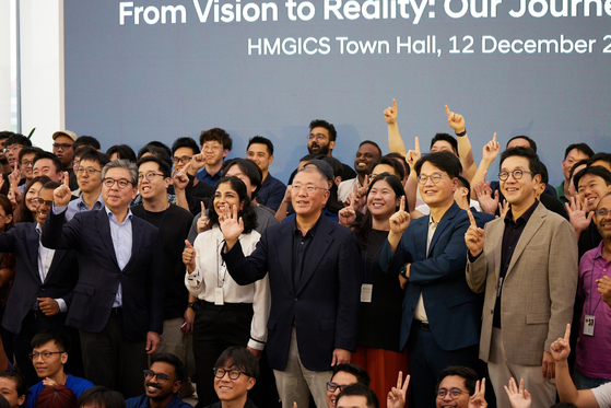Hyundai Motor Group Executive Chair Euisun Chung, center, takes a group photo with workers at Hyundai Motor Group Innovation Center Singapore on Thursday. [HYUNDAI MOTOR] 