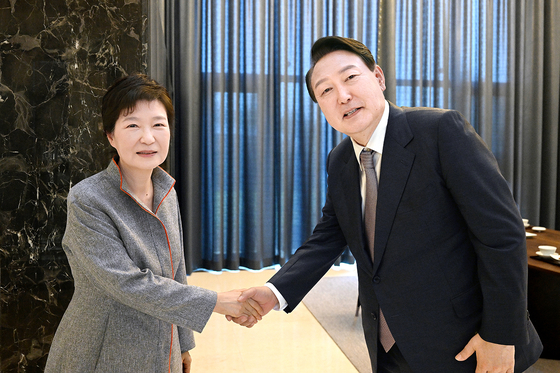 President Yoon Suk Yeol, right, shakes hands with former President Park Geun-hye, in Daegu on April 12, 2022. [YONHAP] 