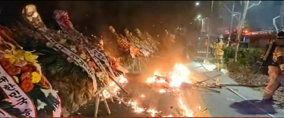 Flower wreaths with written phrases endorsing President Yoon Suk Yeol are set on fire in the early hours of Sunday in Yongsan District, central Seoul. Around 10 wreaths were burnt or damaged by the fire and no casualties were reported. The Yongsan Fire Station mobilized 14 firetrucks and 47 firefighters to contain the blaze which was entirely put out at around 1:43 a.m. Police are investigating the cause of the blaze whether it was an arson or an accident. [YONHAP]