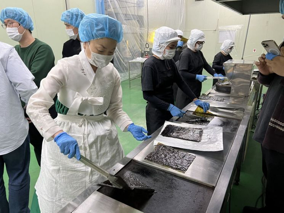 Auntie Omakase #1 passes on her know-how on how to grill gim (dried seaweed) at the production plant of Kwangcheonkim company. [GS RETAIL]