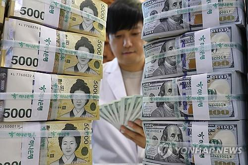 An official checks banknotes at a Hana Bank branch in central Seoul on Dec. 15. [YONHAP]