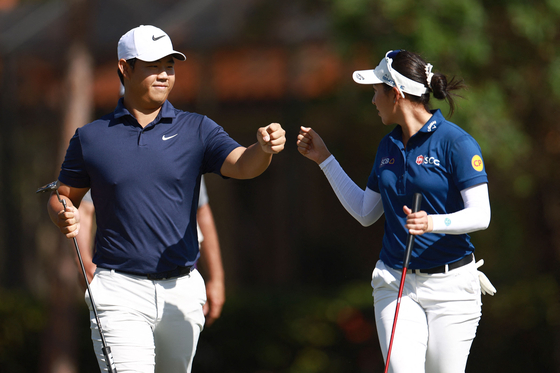 Tom Kim, left, walks with Jeeno Thitikul during the final round of the Grant Thornton Invitational at Tiburon Golf Club in Naples, Florida on Dec. 15. [AFP/YONHAP] 