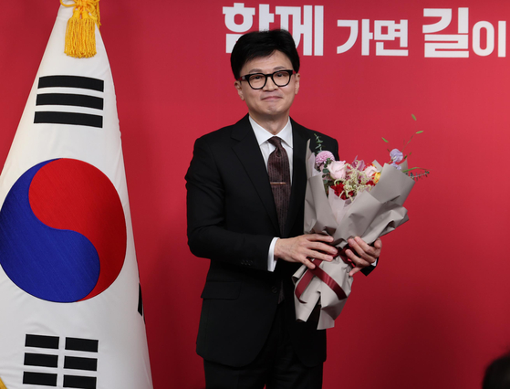 Then-interim chief of the conservative People Power Party Han Dong-hoon holds a flower bouquet at the party's headquarters in western Seoul on Dec. 26 last year. [JOINT PRESS CORPS]