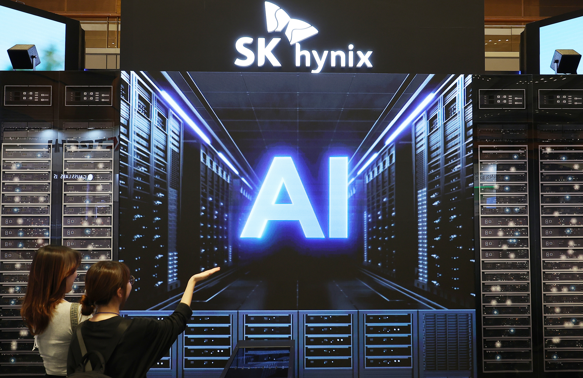 People look at an AI-related video on display at the booth of Korean chipmaker SK hynix at a semiconductor trade show held in southern Seoul on Oct. 2. [YONHAP]