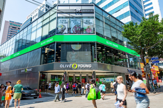 Pedestrians walk by a Olive Young store in Myeong-dong, central Seoul. [CJ OLIVE YOUNG]
