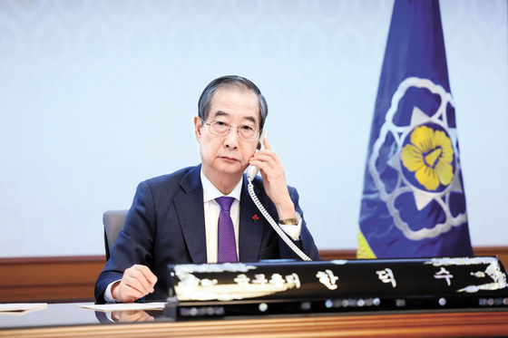 Acting President Han Duck-soo speaks on the phone with U.S. President Joe Biden at the Seoul Government Complex in Jongno District, central Seoul on Sunday. [YONHAP]
