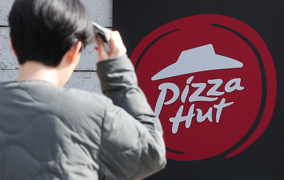 A pedestrian walks by a Pizza Hut store in Seoul on Nov. 5. The Seoul Bankruptcy Court initiated corporate rehabilitation proceedings for Pizza Hut Korea on Dec. 16. [NEWS1]