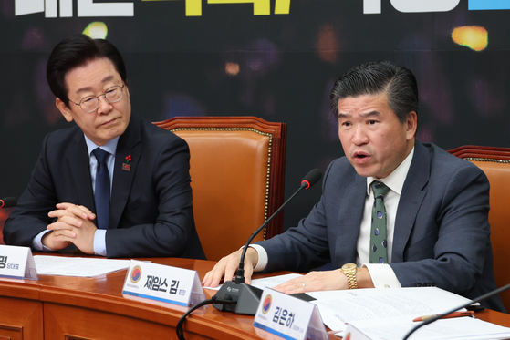 Amcham Chairman James Kim speaks at the National Assembly in western Seoul on Dec. 16 alongside Democratic Party leader Lee Jae-myung. [YONHAP]