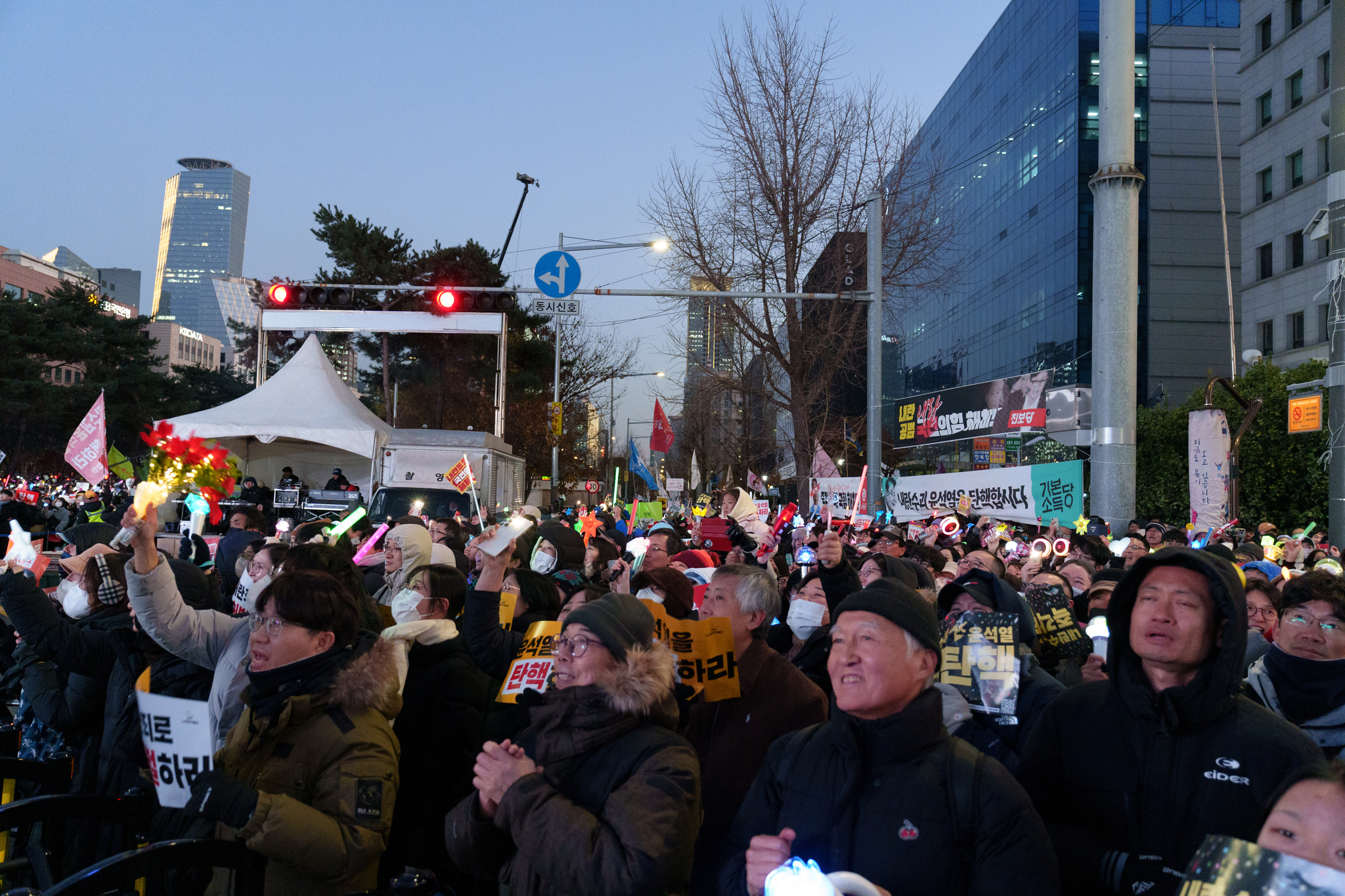 Protesters in front of the National Assembly in western Seoul cheer and smile after the impeachment vote result was announced on Saturday. [CHO YONG-JUN]