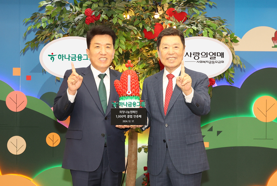 Hana Financial Group Chairman Ham Young-joo, left, and Community Chest of Korea Chairman Kim Byong-joon pose for a photo during a donation ceremony in Jung District, central Seoul on Dec. 17. [HANA FINANCIAL GROUP]