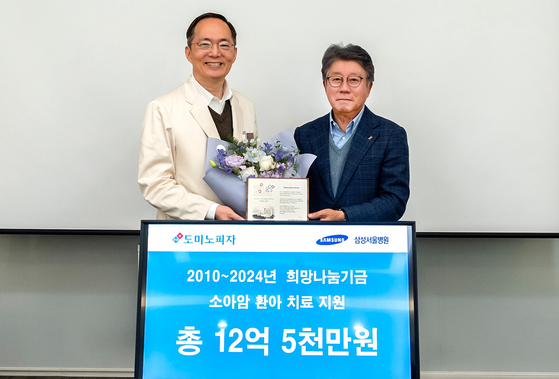 Domino's Pizza Korea Chairman Kenny Oh, right, poses for the camera during a donation ceremony at Samsung Medical Center on Tuesday. [DOMINOS PIZZA KOREA] 