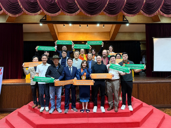 Attendees of the Sunfull Foundation's K-Respect campaign, including Min Byoung-chul, founder of the nonprofit Sunfull Foundation, fourth from left, Antonio Tamayo, member of the board of directors at the University of Perpetual Help System Dalta, far right, and Marissa Magsino, OFW Party List representative, fifth from left, hold banners to respect foreigners at the University of Perpetual Help in Manila, Philippines, on Nov. 27. [SUNFULL FOUNDATION] 