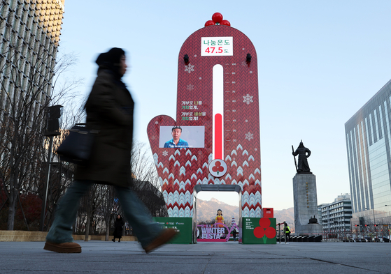 A pedestrian walks by the “Temperature Tower of Love″ installed in Gwanghwamun Square in central Seoul on Dec. 19. The electronic display shows that the public donation score is at 47.5 degrees Celsius, lower than that of last year’s same period, which was 52 degrees Celsius. The Community Chest of Korea, a non-profit fundraising organization, attributed the low achievement to a strained economy and uncertain domestic situation. [NEWS1]