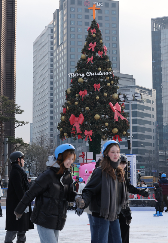 Visitors to the Seoul Plaza ice rink in Jung District, central Seoul, enjoy ice skating on Friday, the opening day. [NEWS1]