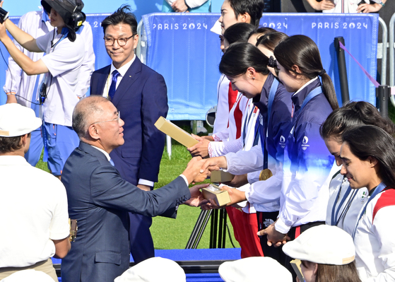 Hyundai Motor Group Executive Chair Euisun Chung delivers gold medals to Korean archers Jeon Hun-young, Lim Si-hyeon and Nam Su-hyeon as they beat China in the women's team archery gold medal match to win Korea’s 10th straight Olympic gold in the event at the Invalides in Paris in July. [HYUNDAI MOTOR] 