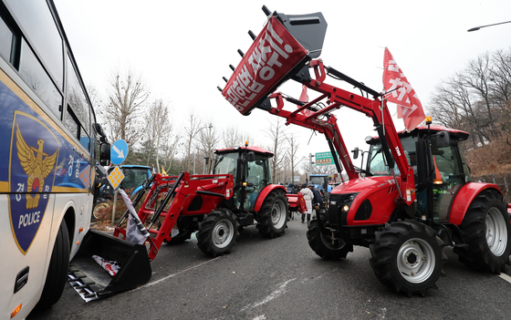Tractors driven by a farmers' group calling for President Yoon Suk Yeol's arrest are stopped by police in southern Seoul on Dec. 21. [NEWS1]