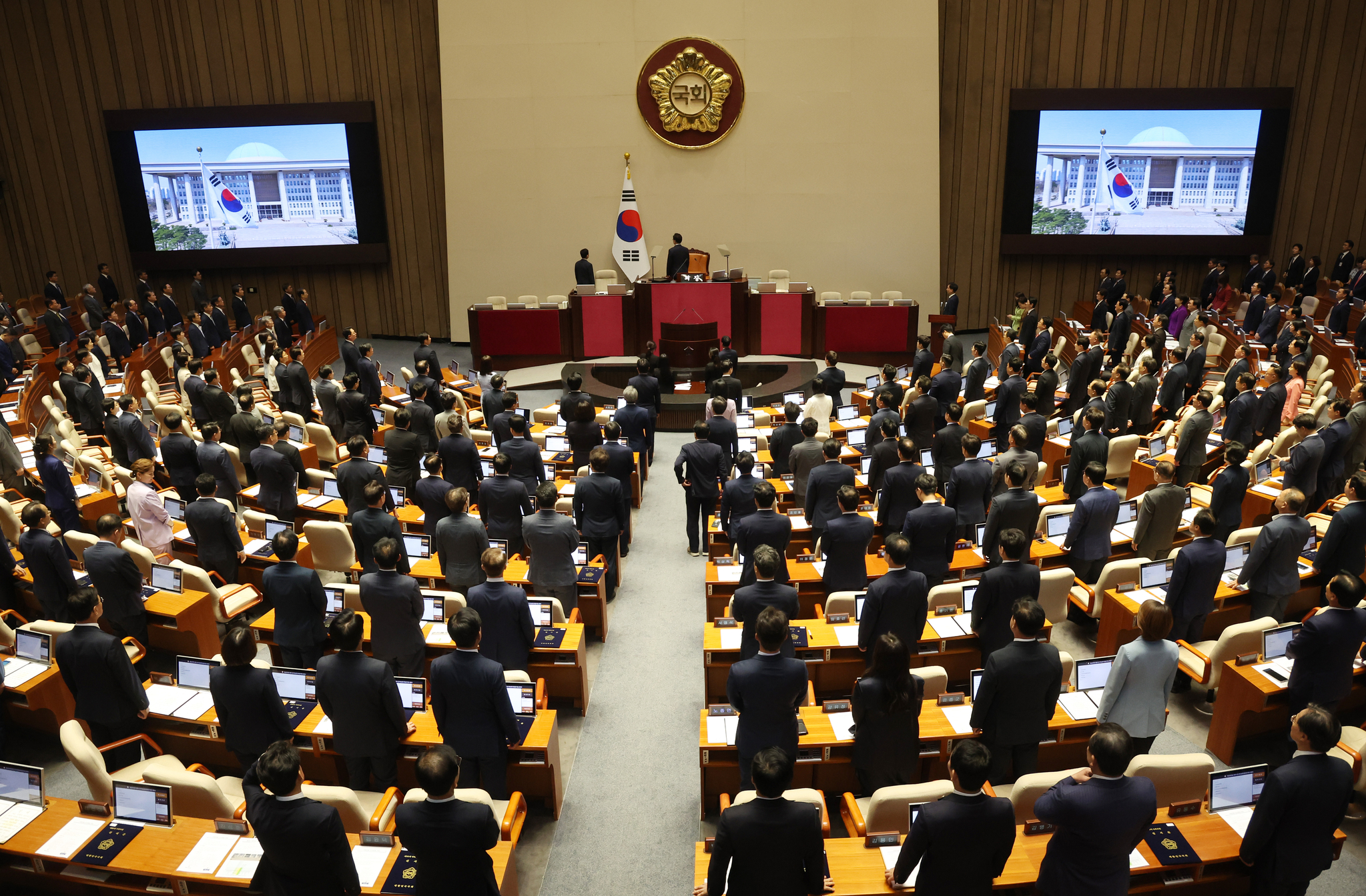 Lawmakers stand in the legislature's plenary chamber in Yeouido, western Seoul, during the official opening ceremony for the 22nd National Assembly on Sept. 2. [YONHAP] 