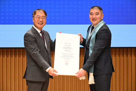 Ruslan Kairambayev from Kazakhstan, right, poses for a photo with Kim Sang-han, first vice mayor of the Seoul Metropolitan Government, during the honorary citizenship ceremony at the City Hall in central Seoul on Friday. [SEOUL METROPOLITAN GOVERNMENT] 
