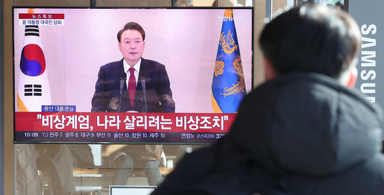 A person watches President Yoon Suk Yeol's televised public address in a waiting room at Seoul Station in Jung District, central Seoul, on Dec. 12. [NEWS1]