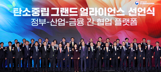 Acting President Han Duck-soo, 10th from right in front, poses for a photo with participants at the carbon neutral grand alliance declaration ceremony held at the Grand Hyatt Seoul in Yongsan District, central Seoul, on Dec. 23. [YONHAP]