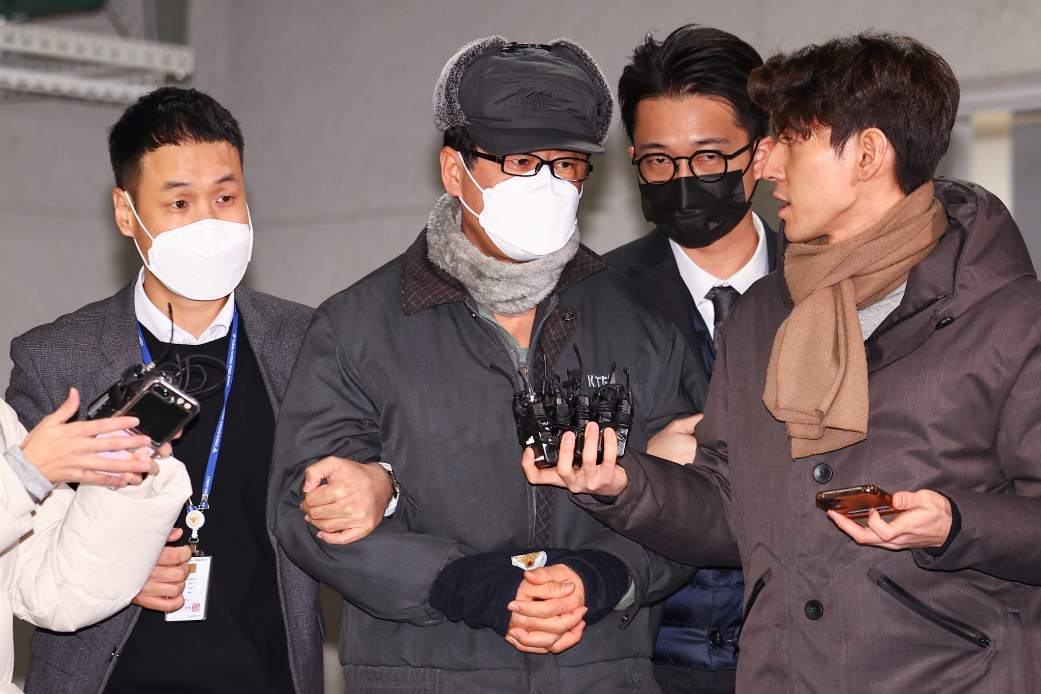 Former Defense Intelligence Command chief Noh Sang-won, second from left, is approached for comment by reporters while leaving the Seoul Seobu Police Precinct in Eunpyeong District, western Seoul, to be handed to prosecutors on Dec. 24. [YONHAP]