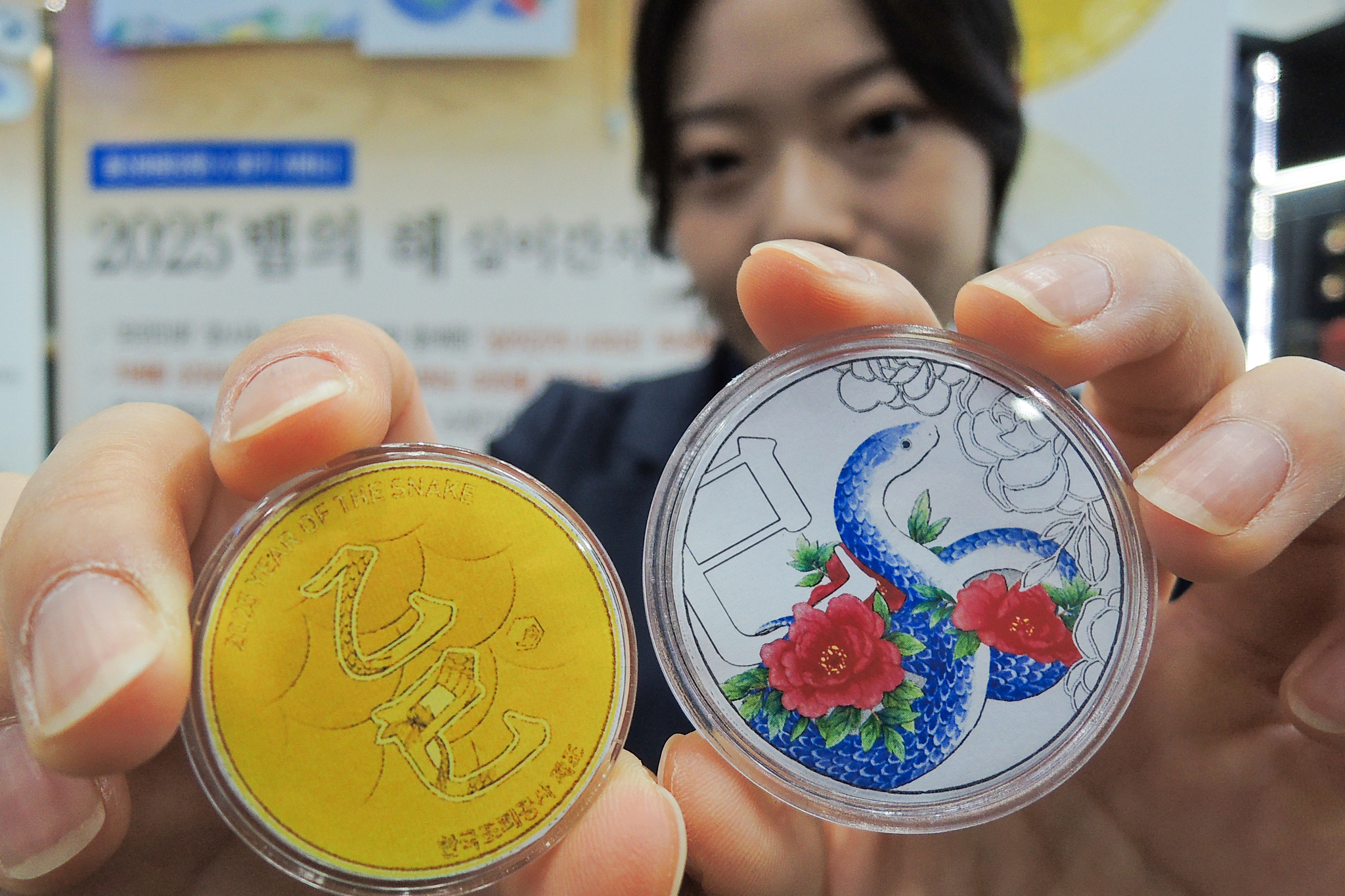 An employee holds out medals that celebrate 2025, the year of the snake. [YONHAP] 