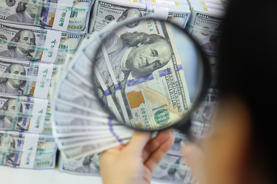 An employee inspects dollar bills at Hana Bank's Counterfeit Notes Response Center in Jung District, central Seoul, on Dec. 19, when the won-dollar exchange rate soared above the 1,450-won-per-dollar mark for the first time in 15 years and nine months. [YONHAP]