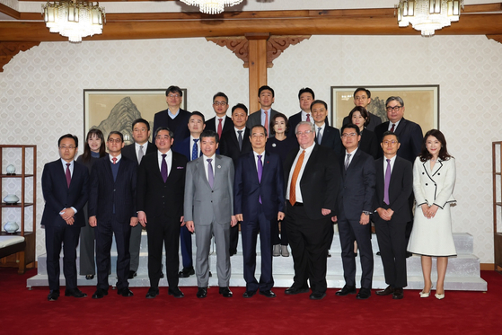 Prime Minister Han Duck-soo, center in the first row, who is currently serving as acting president, and attendees of a luncheon with the American Chamber of Commerce in Korea pose for a photo after their closed-door meeting on Dec. 26. [AMCHAM]