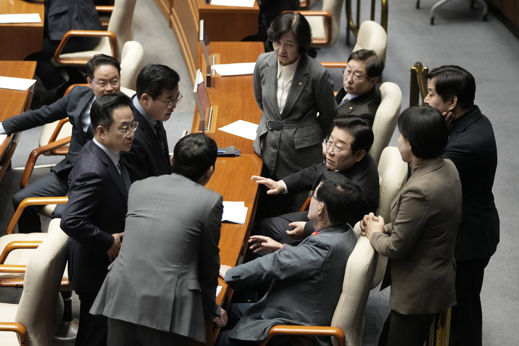 Democratic Party leader Lee Jae-myung, third from right, talks with party members during the plenary session at the National Assembly in Yeouido, western Seoul, on Dec. 26. [AP/YONHAP]