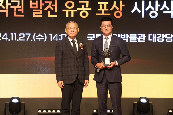 Minister of Culture, Sports and Tourism Yu In-chon left, and SLL JoongAng CEO Yun Ki-yun pose for a photo during the inaugral Korea Copyright Protection Awards ceremony held Wednesday. [SLL JoongAng] 