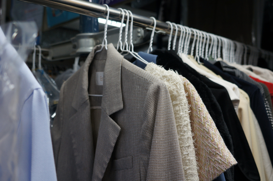 Clothes are hung on a rack at Kim Seon-mi's dry cleaner in Suwon, Gyeonggi. [KIM JU-YEON]