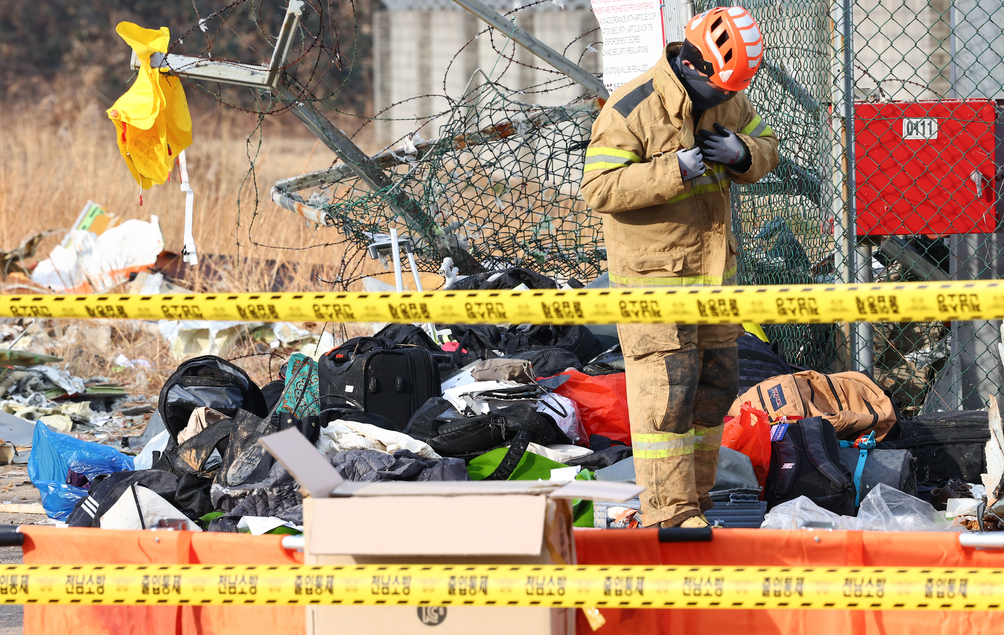 A firefighter is seen searching for remains and debris in an airplane crash site at Muan International Airport on Dec. 29. [YONHAP]