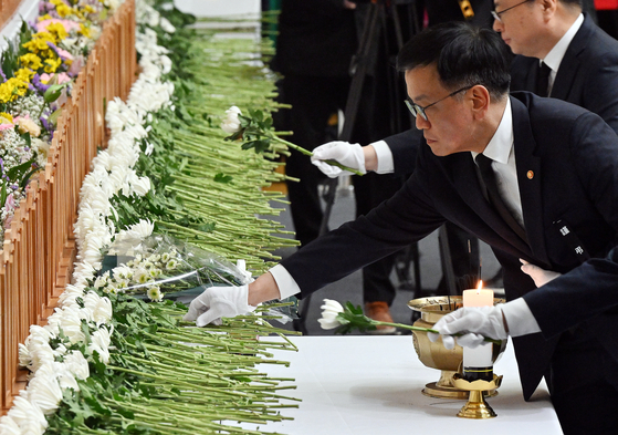 Acting President Choi Sang-mok places a flower and expresses his condolences to the victims at a joint memorial altar in Muan County, South Jeolla on Dec. 30. [JANG JIN-YOUNG] 