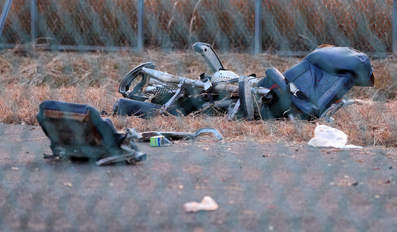 Debris from Jeju Air's aircraft is scattered near the runway at Muan International Airport in South Jeolla on Dec. 29. [NEWS1] 