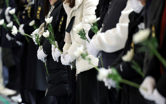 Visitors pay their respects at the joint memorial altar for those who died in Sunday's deadly Jeju Air plane crash at Muan International Airport in South Jeolla on the morning of Dec. 30. [JOONGANG ILBO]
