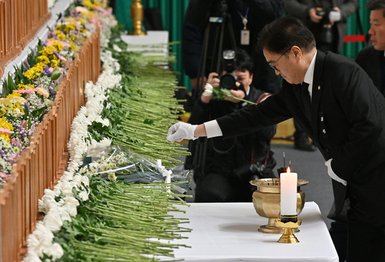 National Assembly Speaker Woo Won-shik on Monday places wreaths at a memorial altar set up in Muan Sports Complex in Muan, South Jeolla, for bereaved families of the victims of Sunday’s Jeju Air crash. [JOONGANG ILBO] 