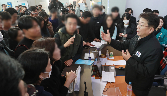 Transport Minister Park Sang-woo, right, speaks to bereaved families at a waiting room at Muan International Airport in South Jeolla on Dec. 31, 2024. [JOINT PRESS CORPS]