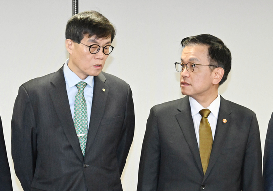 Bank of Korea Gov. Rhee Chang-yong, left, and Minister of Economy and Finance Choi Sang-mok converse during a meeting in central Seoul on Dec. 19. [MINISTRY OF ECONOMY AND FINANCE]