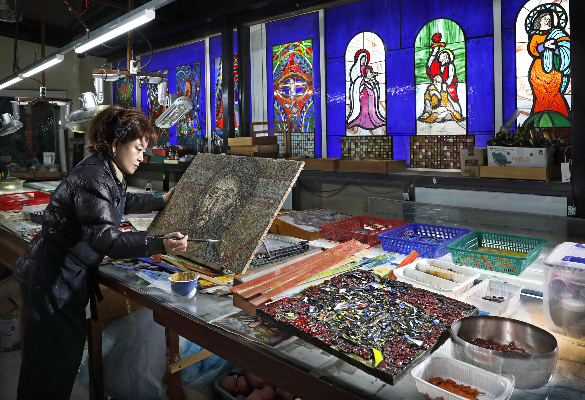 Stained glass artist Choi Wook-mi, the head of Piniel Sculpture Art Research Institute, adds finishing touches to her work at the institute in Anseong, Gyeonggi. [PARK SANG-MOON] 