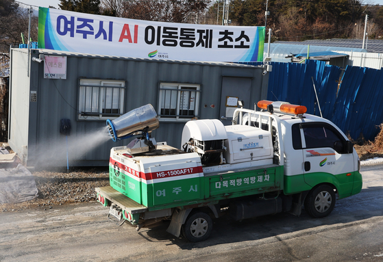 A vehicle sprays disinfectant along a road in Yeoju, Gyeonggi, on Dec. 27, after avian influenza broke out at an egg farm in the area. [YONHAP] 
