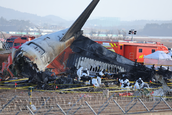 A police forensic team conducts an on-site investigation at the scene of the Jeju Air crash at Muan International Airport in Muan, South Jeolla, on Dec. 31. [YONHAP]