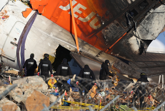 Search operations are under way by police officers near Muan International Airport on Jan. 4, following the crash of a Jeju Air passenger plane that killed all but two of the 181 people onboard. [YONHAP]