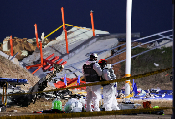 Officials work at the site of a deadly plane crash at Muan International Airport in South Jeolla on Dec. 30, 2024. A Jeju Air passenger plane crashed into a localizer, a navigation system that assists in aircraft landings, has been blamed for exacerbating the severity of casualties in the crash on Dec. 29 that killed all but two of the 181 people onboard. [NEWS1]