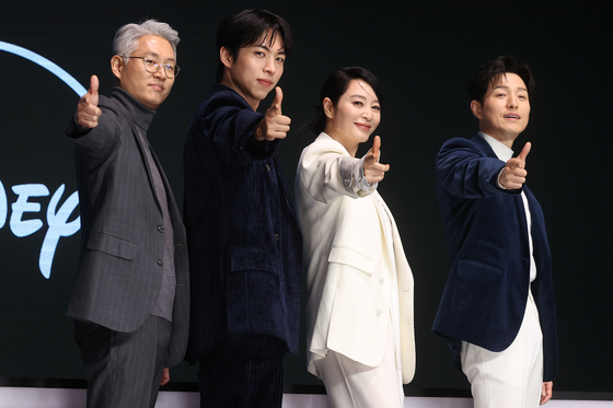 The cast and director pose for photos during a press conference for upcoming Disney+ crime series ″Unmasked″ held in Yeongdeungpo District, western Seoul, on Dec. 8. From left are director You Sun-dong, actors Joo Jong-hyuk, Kim Hye-soo and Jung Sung-il [YONHAP]