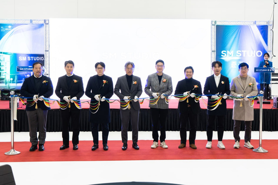 Nam Hwa-min, vice president of SM Life Design, third from right, poses for photos with SM Entertainment executives including the agency's co-CEOs Jang Cheol-hyuk and Tak Young-jun (fourth and fifth from left) at the opening ceremony of SM Studio on Dec. 11, 2024, at the newly-opened studio in Paju, Gyeonggi. [SM LIFE DESIGN]
