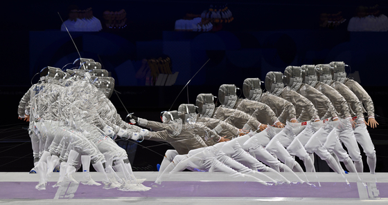 The Winning Point - Gold Medal - Other. Two athletes perform in the sabre during the Paris Olympics.  [PETER SZALMAS/WSPA]