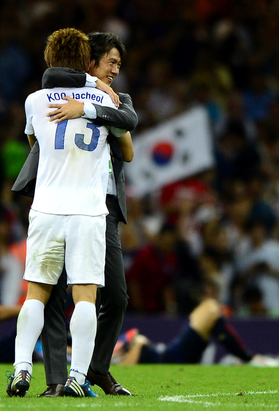 Koo Ja-cheol embraces coach Hong Myung-Bo after Korea secures their first and only Olympic medal over Japan in the 2012 London Olympics.  [JOINT PRESS CORPS]