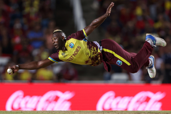 Super Dre - Gold Medal - Cricket. Andre Russell of West Indies fields off his own bowling during the Men’s T20 World Cup.  [DARRIAN TRAYNOR/WSPA]